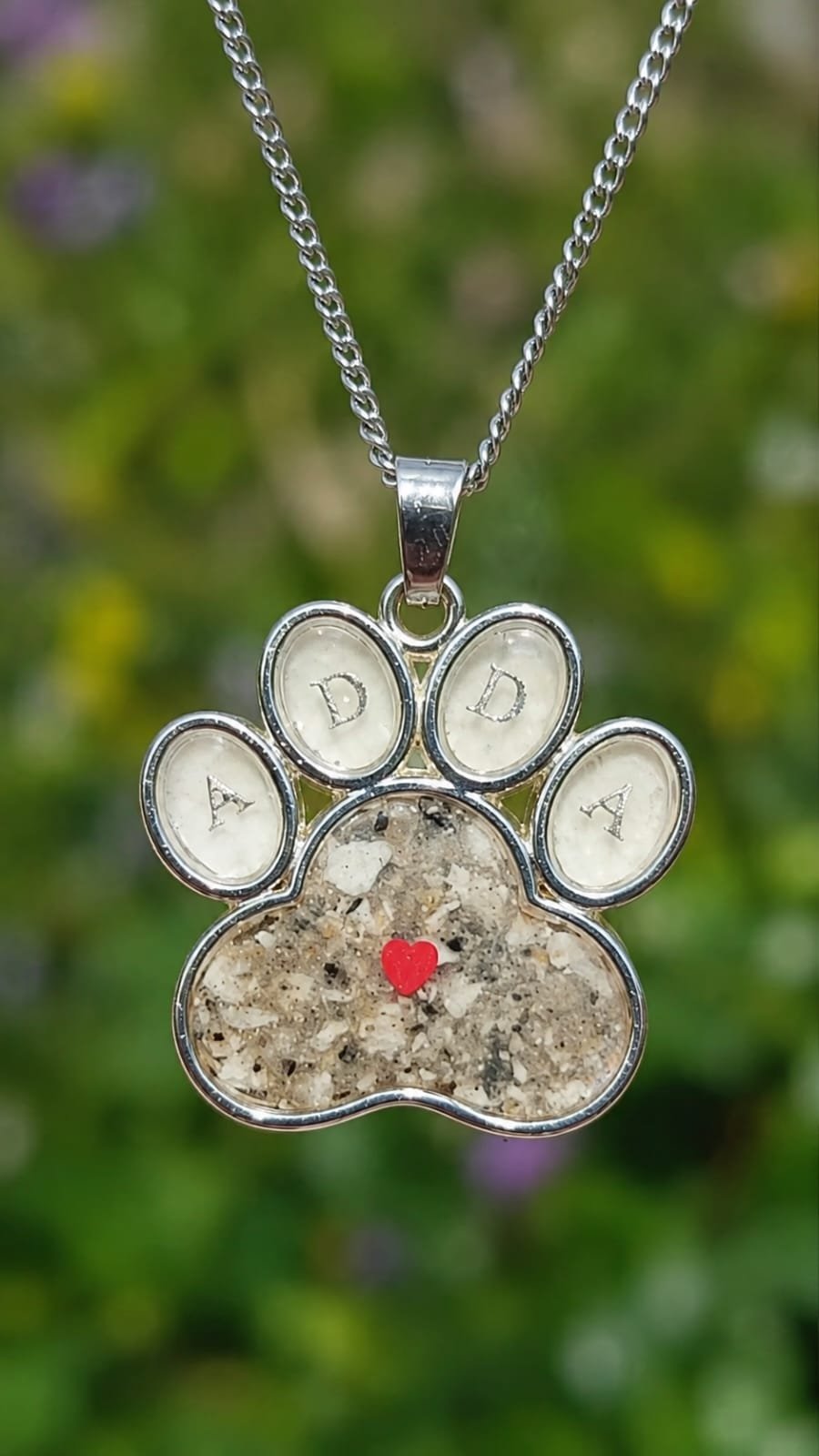 Dije memorial en forma de huellita con cenizas de mascota